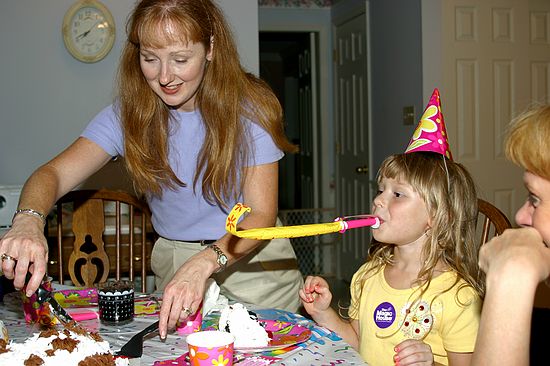 Mom cuts cake, Kristen has fun