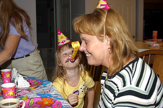 Kristen blowing party favor in Grandma's face